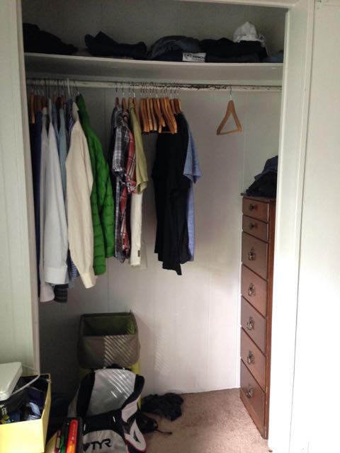 Tidied closet with shirts spaced on wooden hangers and a small dresser, leaving open space