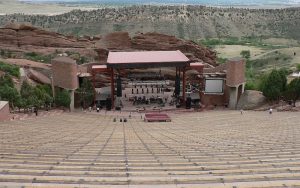Rows of empty benches at Red Rocks Amphitheatre leading down to the stage between red rock formations